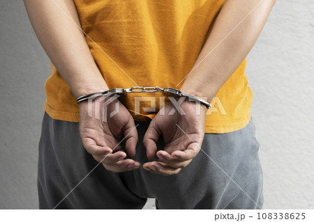 Arrested man with a handcuff on his hand Arrested man with a handcuff on his hand 108338625