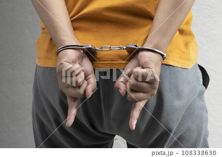 Arrested man with a handcuff on his hand Arrested man with a handcuff on his hand 108338630