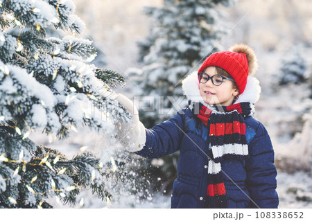 Small girl playing with snow. Happy preschool child in winter forest on snowy cold december day. Small girl playing with snow. Happy preschool child in winter forest on snowy cold december day. 108338652