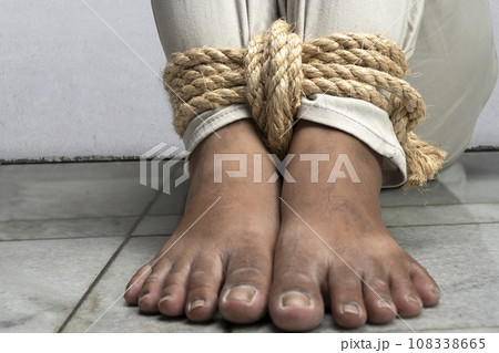 The man's legs are tied by rope The man's legs are tied by rope 108338665
