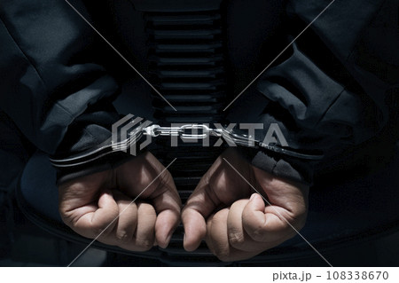 The man was sitting on a chair with tied hands in handcuffs The man was sitting on a chair with tied hands in handcuffs 108338670