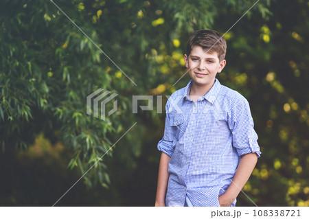 Handsome Teenager Boy Poses Outdoors, Exuding Confidence and Style in a Captivating Portrait. Happy Preteen Child. 108338721