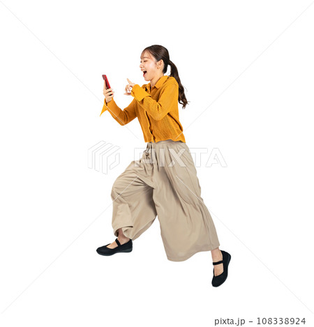 スマホを使いながらジャンプするカジュアルウェアを着た女性 切り抜き背景透過写真PNG スマホを使いながらジャンプするカジュアルウェアを着た女性 切り抜き背景透過写真PNG 108338924