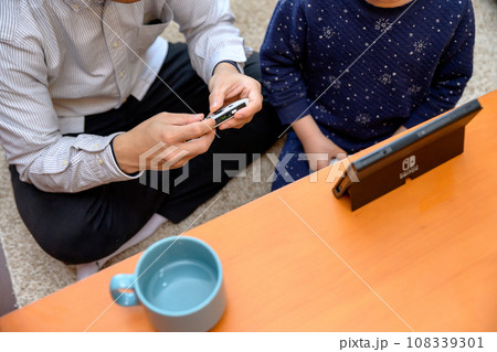 父親と家庭用ゲーム機で遊ぶ子ども　対戦　仲良し　家庭　イクメン　リモートワーク　 108339301