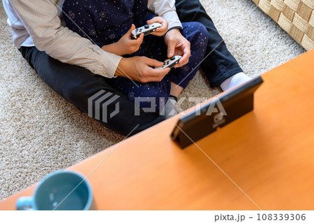 父親と家庭用ゲーム機で遊ぶ子ども 対戦 仲良し 家庭 イクメン リモートワーク 父親と家庭用ゲーム機で遊ぶ子ども 対戦 仲良し 家庭 イクメン リモートワーク 108339306
