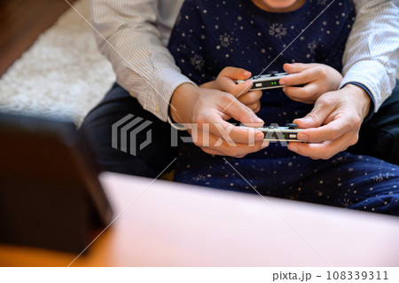 父親と家庭用ゲーム機で遊ぶ子ども 対戦 仲良し 家庭 イクメン リモートワーク 父親と家庭用ゲーム機で遊ぶ子ども 対戦 仲良し 家庭 イクメン リモートワーク 108339311