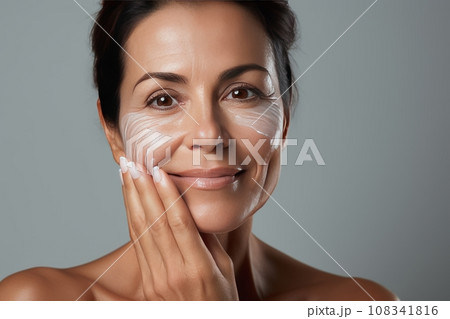 Skin beauty. Woman's head and shoulders, touching fresh, moisturized facial skin, applying toner, skin cream or lotion for a healthy look. Skin beauty. Woman's head and shoulders, touching fresh, moisturized facial skin, applying toner, skin cream or lotion for a healthy look. 108341816