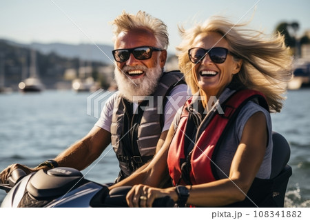 Senior happy couple having fun on jet ski at beach island hopping tour - Active elderly and travel concept around the world with retired people riding water scooter jetski 108341882