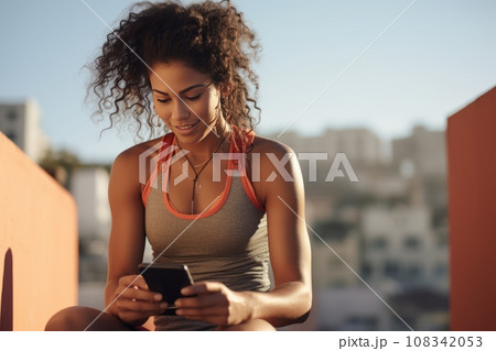 A young girl chooses music on her smartphone for her morning workout. sport and modern technology 108342053