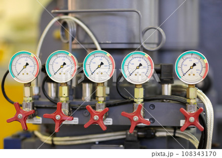 closeup of industrial machine with pressure gauges 108343170