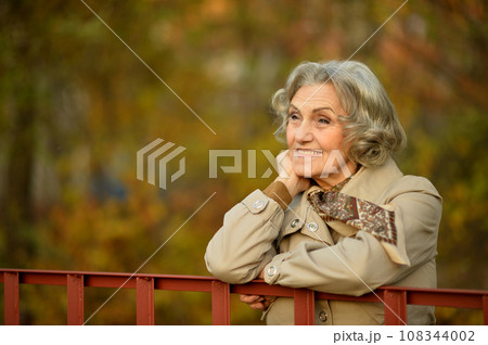 Senior woman walking in the park in autumn. Senior woman walking in the park in autumn. 108344002