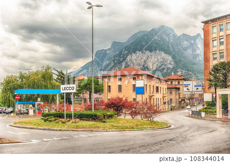 City intersection with scenic mountain in the background, Lecco, Italy 108344014