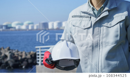 ヘルメットと作業服の男性・海と工業地帯│建設業・製造業・プラント　イメージ 108344525