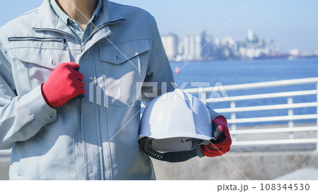 ヘルメットと作業服の男性・海と工業地帯│建設業・製造業・プラント　イメージ 108344530