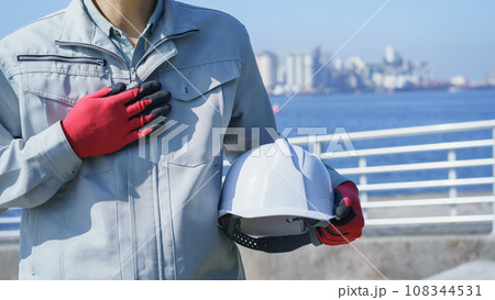 ヘルメットと作業服の男性・海と工業地帯│建設業・製造業・プラント　イメージ 108344531
