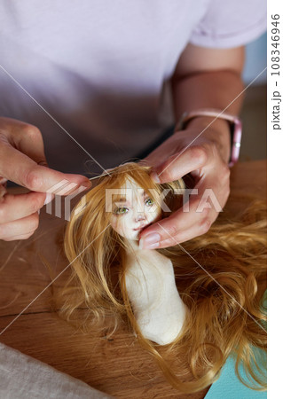 Creative young adult woman making handmade doll. Creative young adult woman making handmade doll. 108346946