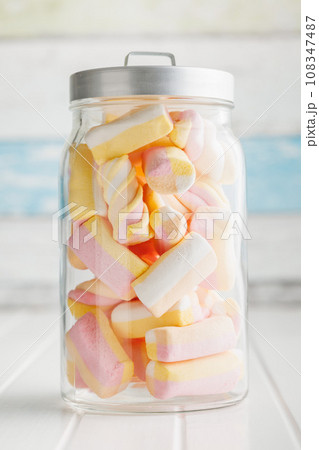 Sweet colorful marshmallows in jar on white kitchen table. 108347487