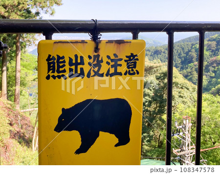 山のフェンスに掲示された熊出没注意の看板 108347578