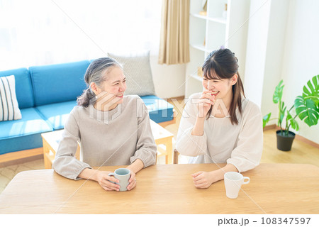 部屋で仲良く話すシニア女性と若い女性 108347597