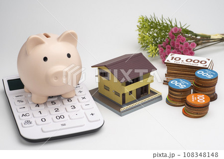 マイホームとおもちゃのお金と貯金箱と電卓 108348148