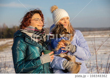 The friends went out for a walk during a winter day. 108348362