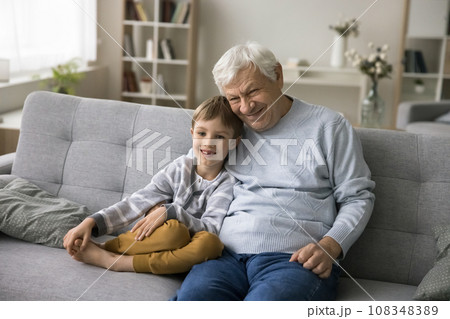 Great-grandpa hugs his cute great-grandson smile look at camera Great-grandpa hugs his cute great-grandson smile look at camera 108348389