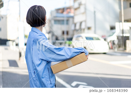 荷物を持つ作業服の女性 荷物を持つ作業服の女性 108348390
