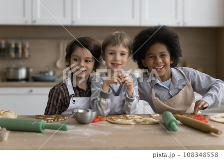 Three multiethnic boys in aprons cooking together in kitchen 108348558