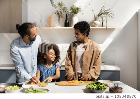 Happy African couple of parents teaching daughter kid to cook Happy African couple of parents teaching daughter kid to cook 108348870