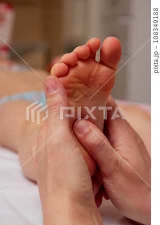 Doctor performing pediatric foot massage to prevent development of flat feet Doctor performing pediatric foot massage to prevent development of flat feet 108349188