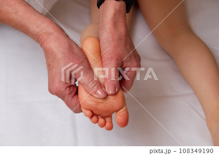 Doctor performing pediatric foot massage to prevent development of flat feet 108349190