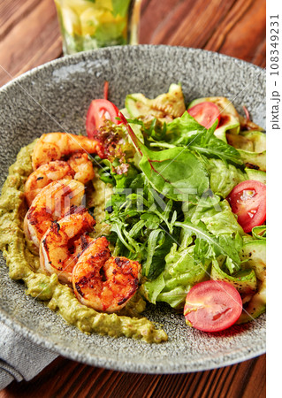 Grilled shrimps with pesto, mix of salads and tomatoes. 108349231