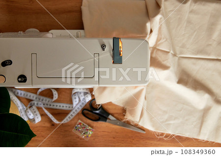 Sewing machine with piece of fabric on table. Sewing machine with piece of fabric on table. 108349360