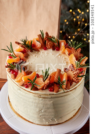 Festive Christmas cake decorated with fruits and rosemary. 108349541