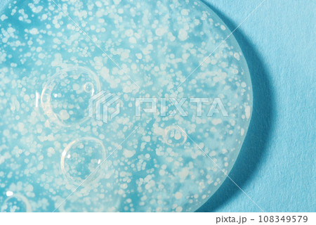 Texture of transparent gel with polishing beads on blue. 108349579