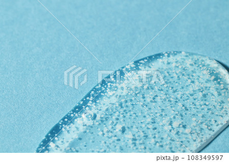 Texture of transparent gel with polishing beads on blue. Texture of transparent gel with polishing beads on blue. 108349597