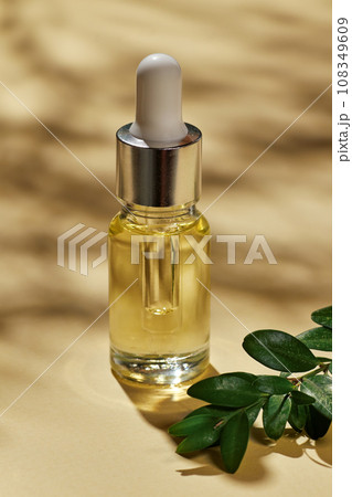 Oil for spa treatment in glass bottle on beige background. Oil for spa treatment in glass bottle on beige background. 108349609