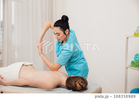 healthy back woman massages client in massage room spa training healthy back woman massages client in massage room spa training 108350989