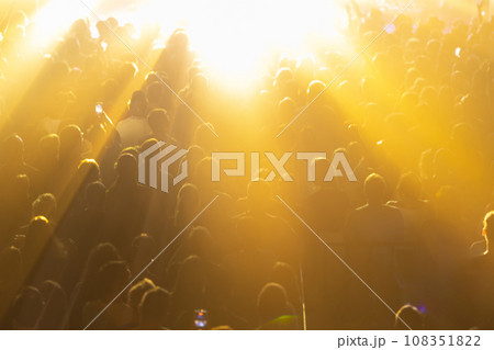 A concert crowd illuminated by bright yellow lights. A concert crowd illuminated by bright yellow lights. 108351822