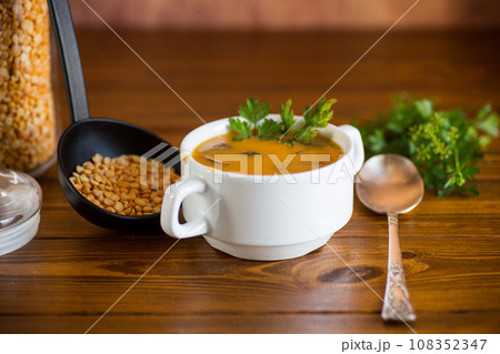 Cooked dried pea puree soup with mushrooms in a bowl . 108352347