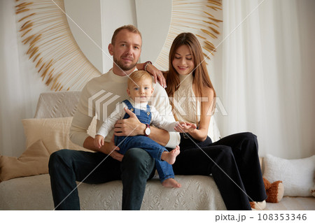 Happy family moments together. Caucasian young happy family nurturing taking care of small little kid child toddler infant baby at home. Parenthood and adoption 108353346