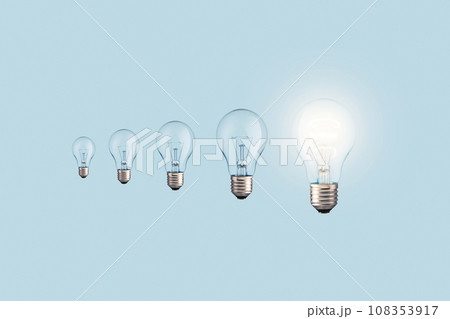 Creative light bulbs loading process and one glowing light bulb on a blue background. Creative idea, concept. Uploading a new idea. Project and success Creative light bulbs loading process and one glowing light bulb on a blue background. Creative idea, concept. Uploading a new idea. Project and success 108353917