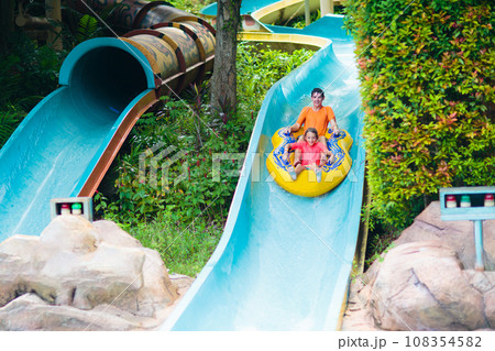 Kids on water slide. Family in aqua theme park. Kids on water slide. Family in aqua theme park. 108354582
