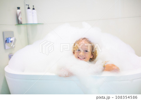 Child playing with foam in bath Child playing with foam in bath 108354586