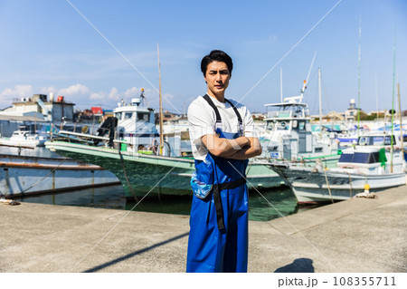 漁港に立つ若い漁業従事者 漁港に立つ若い漁業従事者 108355711