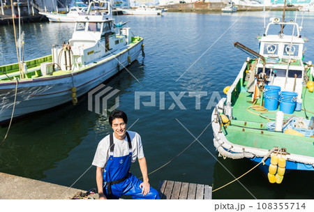 漁港に立つ若い漁業従事者 108355714