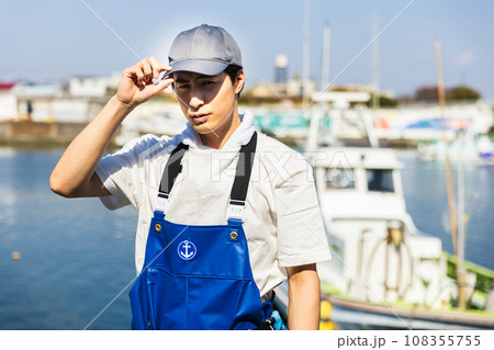 漁港に立つ若い漁業従事者 108355755