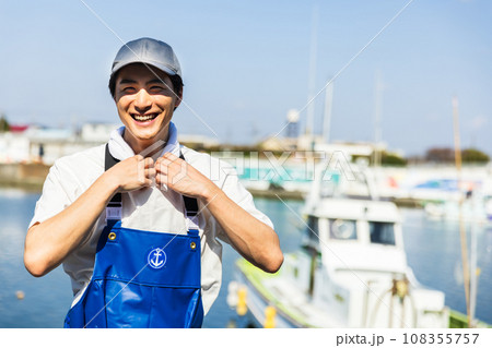 漁港に立つ若い漁業従事者 108355757