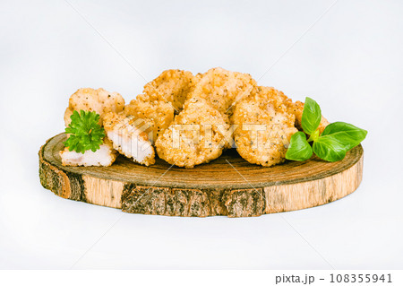 Breaded Chicken Inner Fillet on a White Background,Chicken Breaded Raw Meat.Chicken Breaded Fillet. Breaded chicken nuggets. Fast homemade food at home. Chicken breaded schnitzels. Fast cooking. 108355941