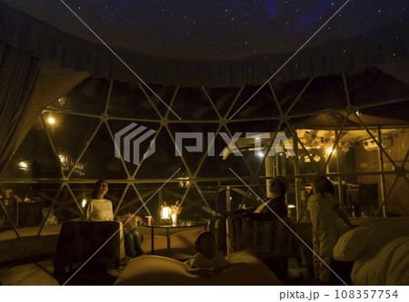 グランピングイメージ　夜ドームテントでプラネタリウムを見る家族 108357754